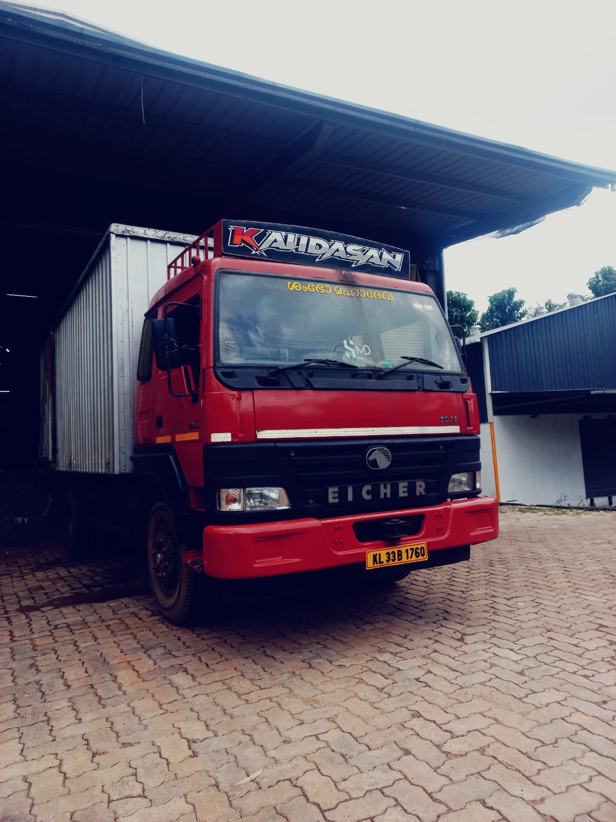 Red Eicher freight truck ready at a warehouse